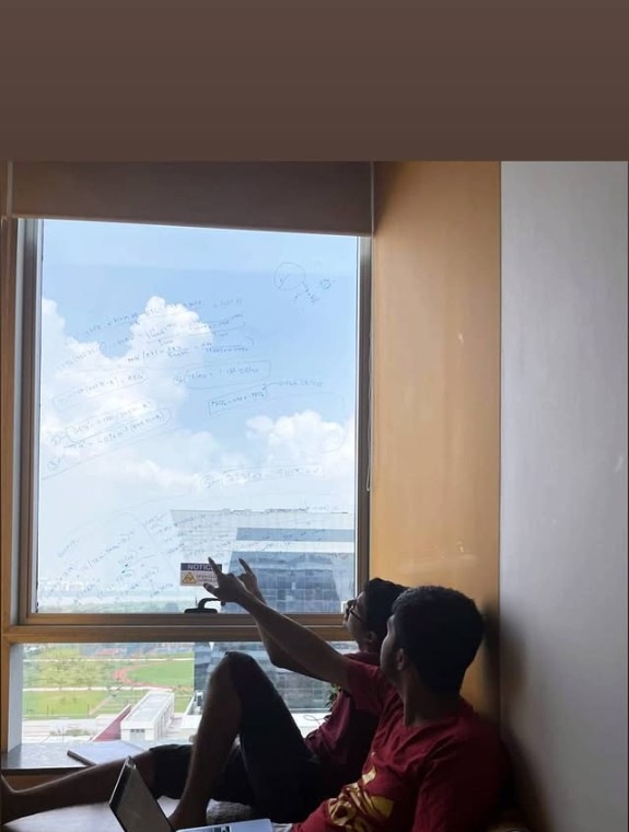 Studying with a classmate at Jio Institute, equations written on the window