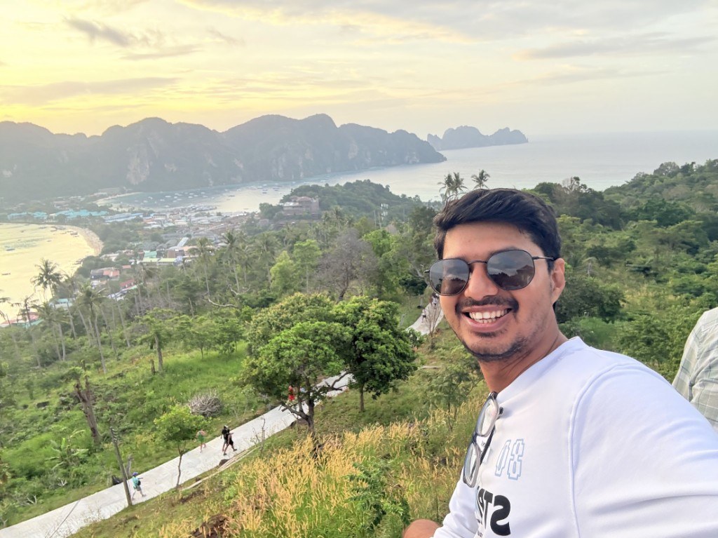 Ronak at a viewpoint over a tropical bay at sunset