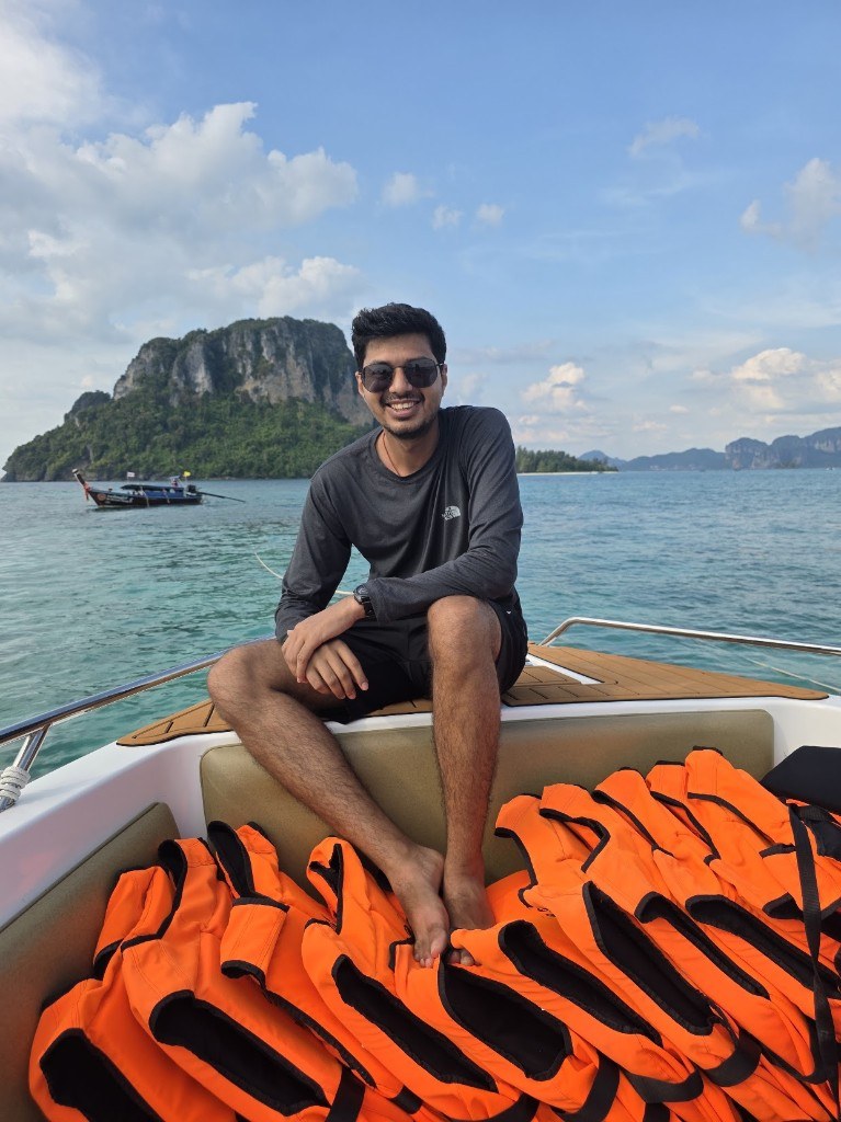 Ronak sitting on a boat near tropical islands