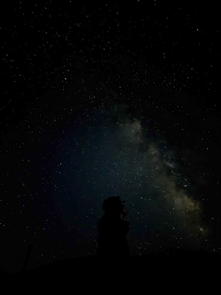 Silhouette under the Milky Way night sky