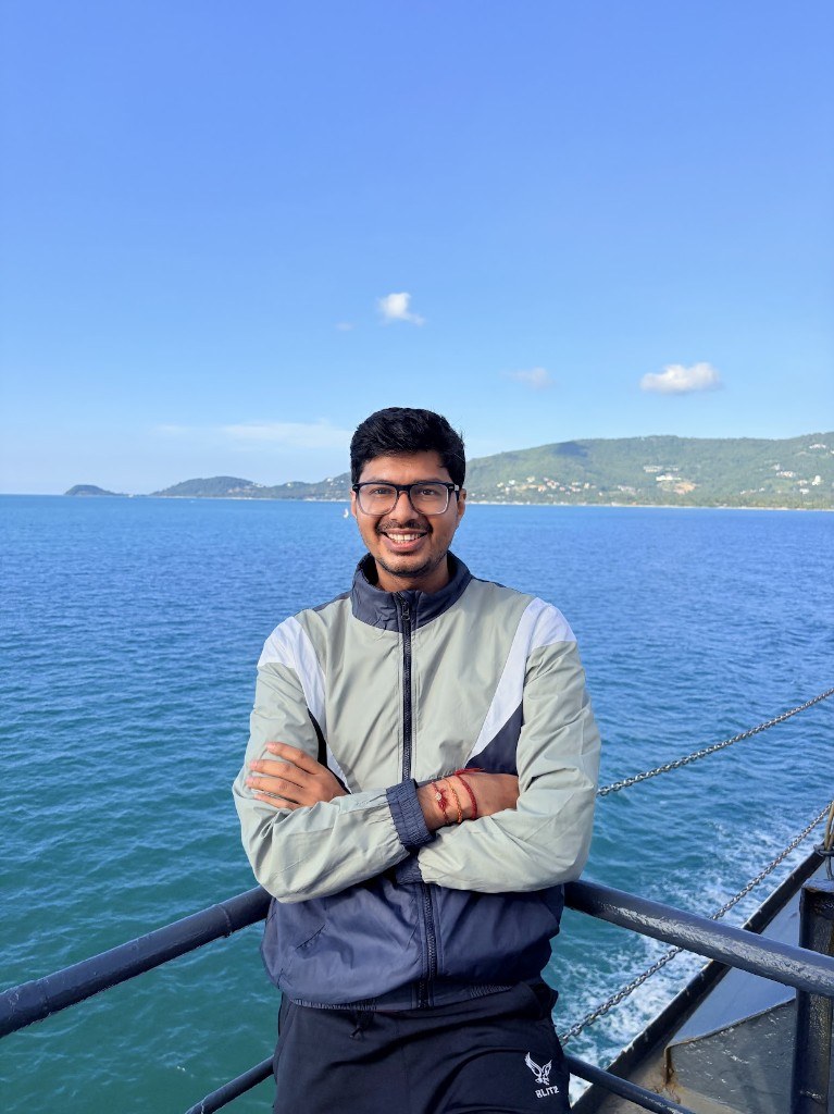 Ronak on a ferry with the sea behind him